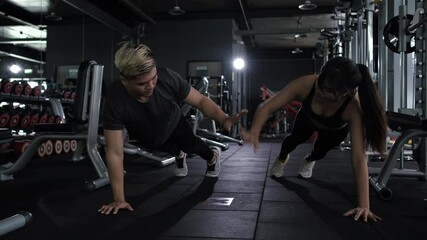 Two friends sporty doing push up with clap exercise on fitness gym floor.