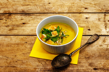 Yellow zucchini cream soup. Healthy vegan (vegetarian) food, crispy toast, sunflower seeds, fresh greens