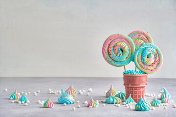 Colorful meringue lollipop in ceramic cone. Closeup with copy space