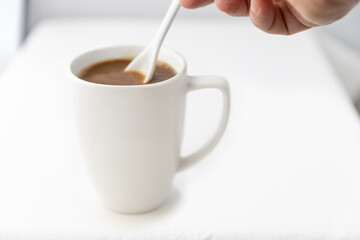 Mixing an Americano style cup of freshley brewed coffee.