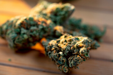 Close up of a heap medical marijuana bud on wooden table at sunshine