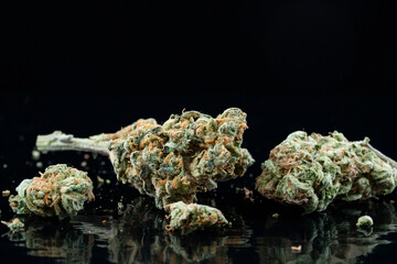 Close up of medical marijuana buds on black reflecting background