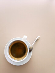 Top view of a paper cup of black coffee on ligth tone table