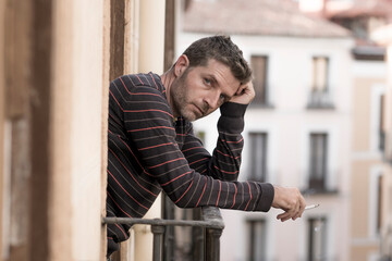 urban lifestyle emotional portrait of young handsome man sad and depressed smoking cigarette...