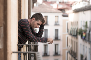 urban lifestyle emotional portrait of young handsome man sad and depressed smoking cigarette...