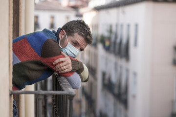 stay home quarantine portrait of of 30s handsome man in face mask sad and depressed at home balcony...