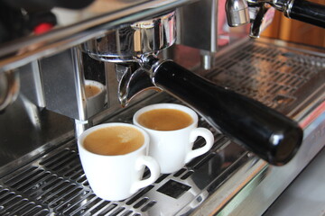 the process of making espresso coffee using a modern machine. cafe kitchen concept, make two cups of coffee latte