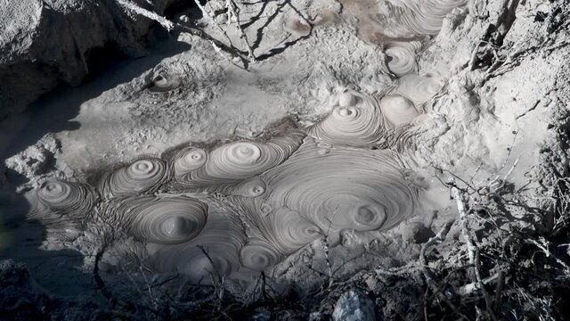 Mud Pools with boiling liquid, natural geothermal valley. Slow motion