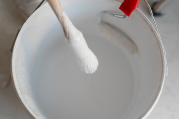 woman twisting the brush to paint her house white