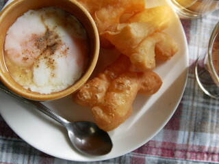 set of moring thai hot drink, coffee with deep-fried dough stick and soft boiled eggs, local thai food and drink.