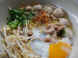 Local thai noodle with soft boiled eggs, vegetable and meat ball in soup bowl  