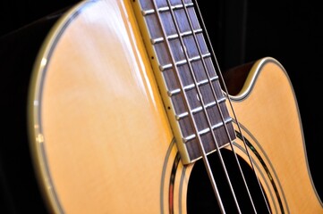 horizontal closeup detail of acoustic bass guitar with black background