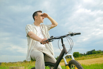 A man on a mountain bike. A fashionable guy came to nature in the field.