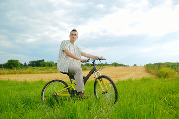 A man on a mountain bike. A fashionable guy came to nature in the field.