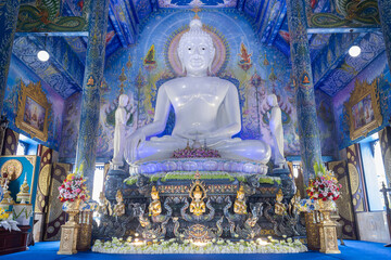 Chiangrai, Thailand - June 7, 2020: White Buddha Sitting in Church and God and Thai mural at Wat Rong Suea Ten or Blue Temple