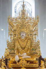 Phayao, Thailand - Dec 8, 2019: White God Statue Wear Gold Apparel in Portrait View with Natural Light in Thai Church at Analayo Temple in Thailand