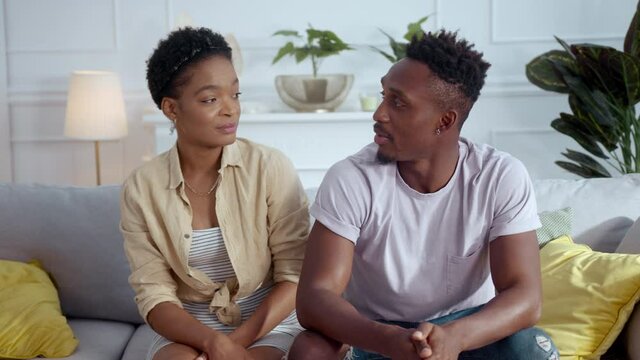 Afro-american mixed race young couple man and woman sharing family problems with psychologist talking at camera about relationships problems.