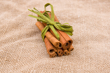 Culinary spices. Cinnamon sticks on a coarse cloth-brown burlap jute or linen cloth
