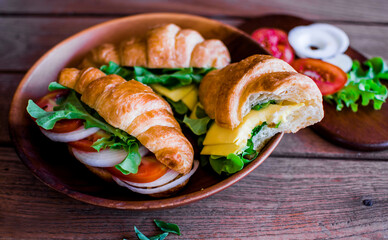 Freshly croissant sandwich on wooden background. It is a type of French pastry suitable as breakfast.