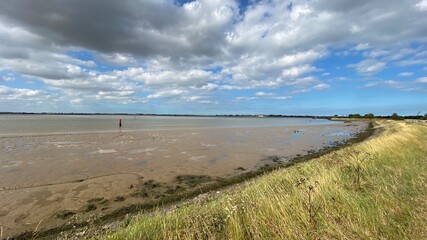 View of the broads National Park from the river bank in a cloudy day shoot taken against the sun with a dramatic sky and strong shadow in Great Yarmouth