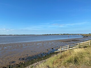 View of the broads National Park from the river bank in a cloudy day shoot taken against the sun with a dramatic sky and strong shadow in Great Yarmouth