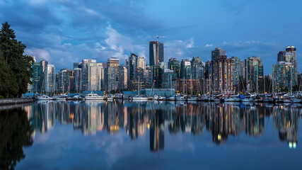 Obraz na płótnie Canvas Blue hour Reflection of Vancouver city, BC, from the Marina at Stanley park, one of the most beautiful urban park in the world.