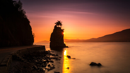 Fototapeta premium Silhouette of Siwash Rock at Sunset in the beautiful Stanley park, Vancouver, British Columbia, Canada