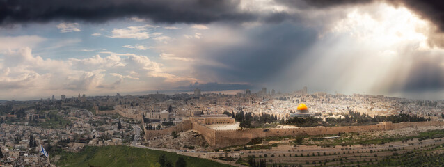 Fototapeta premium Beautiful panoramic aerial view of the Old City, Tomb of the Prophets and Dome of the Rock. Dramatic Sky with Sunrays Composite. Jerusalem, Capital of Israel.