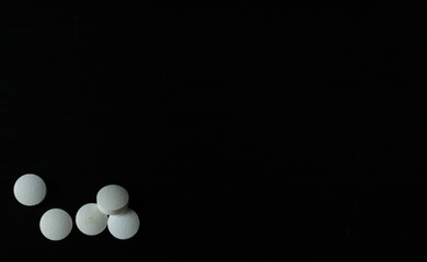 Tabletas o pastillas blancas sobre un fondo negro para mostrar información o algún producto