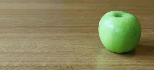 Green apple isolate on oak wood table with copy space