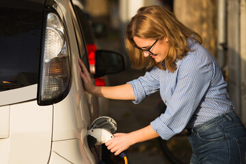 Woman is charging carsharing electric car.	