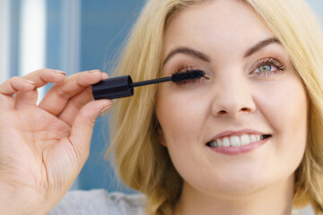 Woman using mascara on her eyelashes