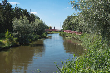 Lokeren, Belgium, Landscape photo with a river, a footbridge and a church tower in the distance