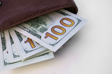 on the top left is a closed men's wallet with dollars sticking out of it