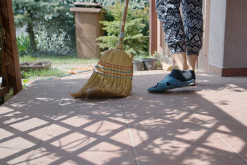 cleaning the porch with a traditional broom