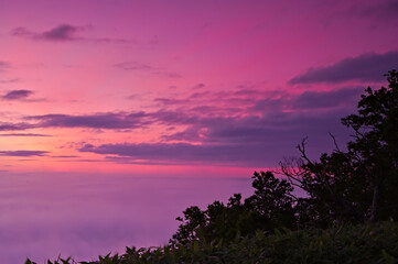 雲海の広がる朝の鮮やかな夜明けの空。津別峠、北海道、日本。