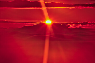 空と雲を赤く染める夜明けの太陽の光線