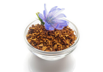 Chicory flower and sublimated root of chicory in the glass bowl isolated on white background