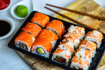 Sushi Set sashimi and sushi rolls served on stone slate