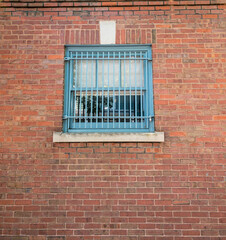 barred window on brick wall of building