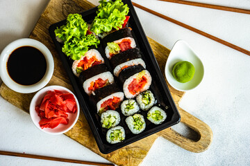 Sushi Set sashimi and sushi rolls served on stone slate