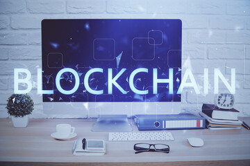 Double exposure of blockchain and crypto economy theme hologram and table with computer background....