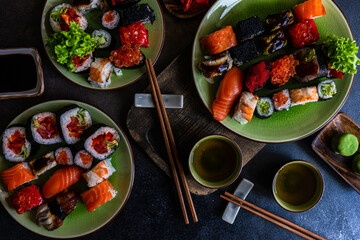 Sushi Set sashimi and sushi rolls served on stone slate