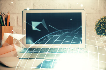 Double exposure of desktop with computer and world map hologram. International data network concept.