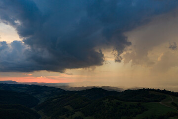 Fototapeta na wymiar Drone view of epic sunset with rainy clouds in Transylvania, Romania.