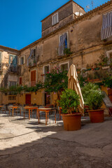 Typowy widok dla południa Włoch - małe klimatyczne budynki, zielona roślinność i dużo słońca - obrazy, fototapety, plakaty