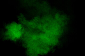 Abstract green powder explosion on black background.Freeze motion of green dust cloud.