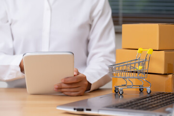 Female seller is checking the number of orders for her products that have been ordered using the tablet. Online Shopping and E-commerce concept.