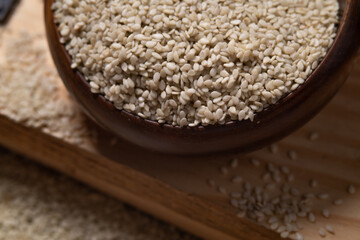Close up. White sesame in a wooden cup.