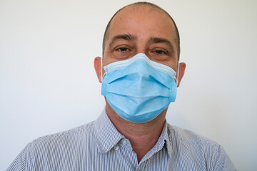 Man wearing a surgical face mask to stop the spread of the Coronavirus Covid 19